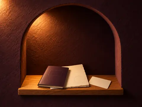 A closed plum passport on a cream certificate, with a card face-down, in a lit arched niche.